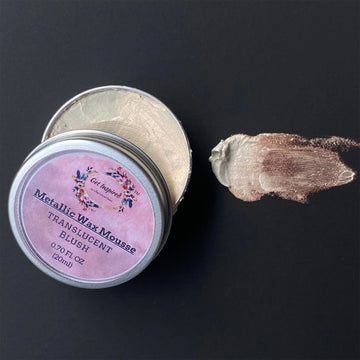 Metallic wax mousse container with pink label on a black background