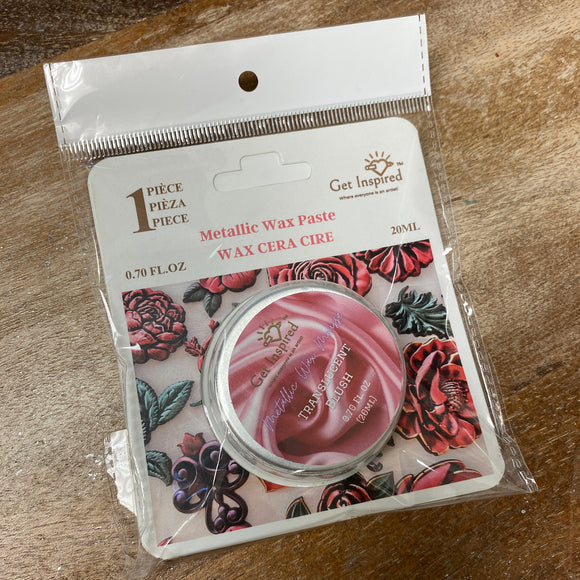 Metallic wax paste packaging with floral design on a wooden surface
