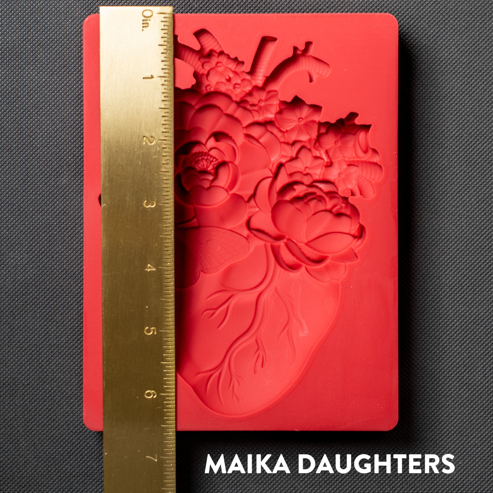 A red silicone mold of Get Inspired by Dadarkar Art's Blooming Heart is against a dark grey background. A gold ruler reading 6.5" height is on the mold.