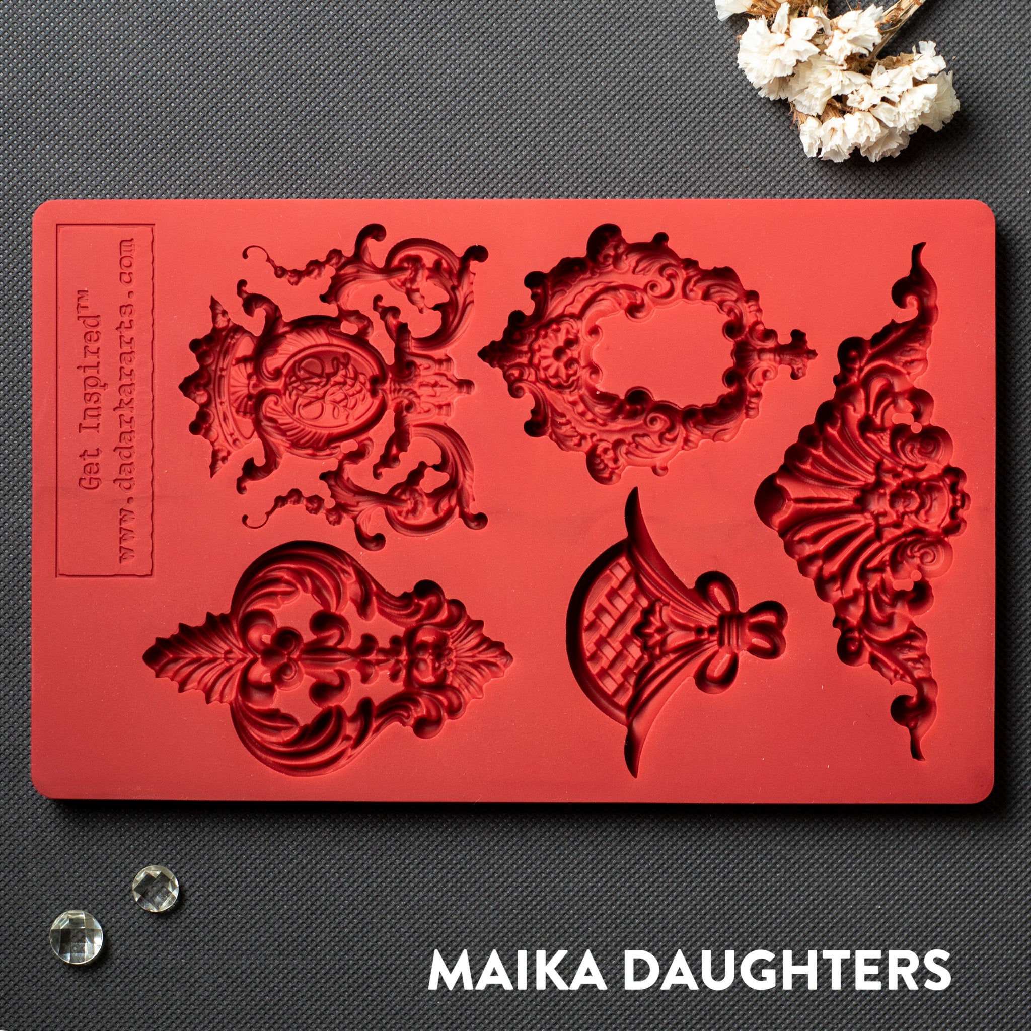 A red silicone mold featuring 5 regal center accent pieces is against a dark grey material background.