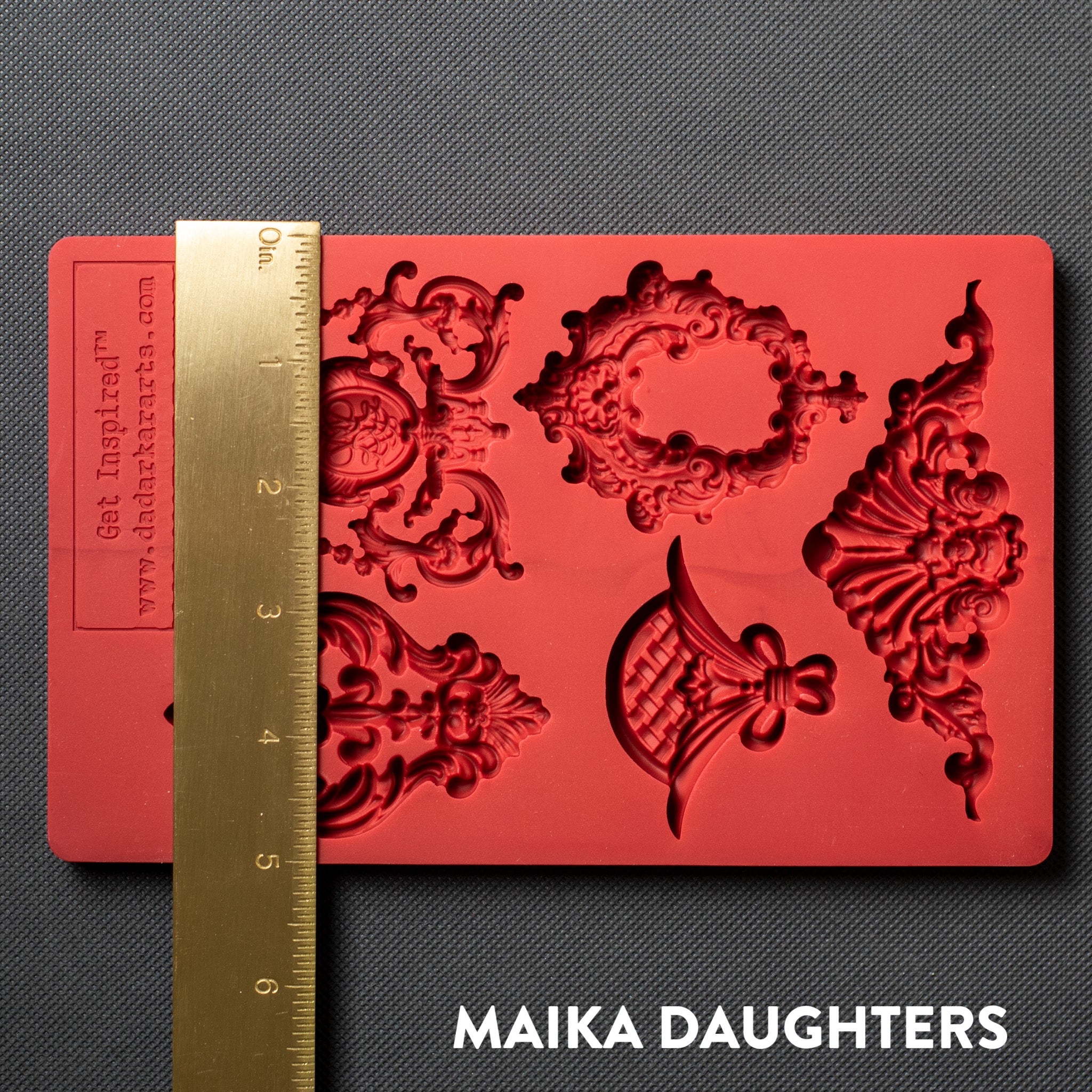 A red silicone mold featuring 5 regal center accent pieces is against a dark grey material background. A gold ruler reading 5" height sits on the mold.