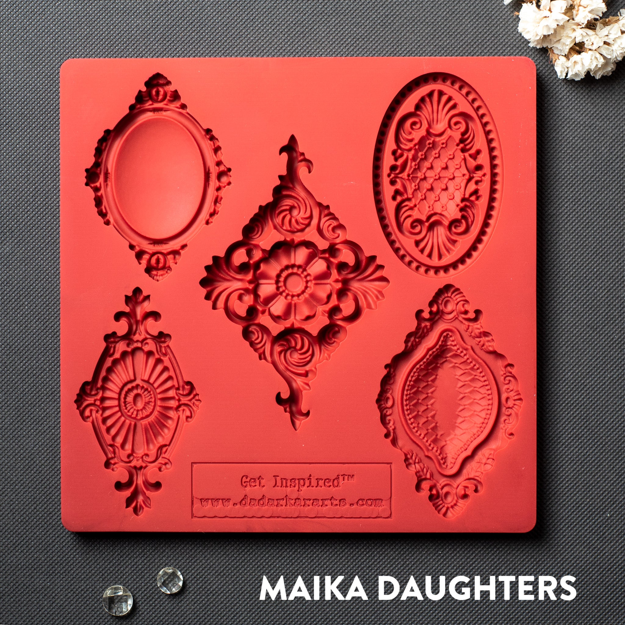 A red silicone mold with featuring 5  vintage medallions is against a dark grey background.