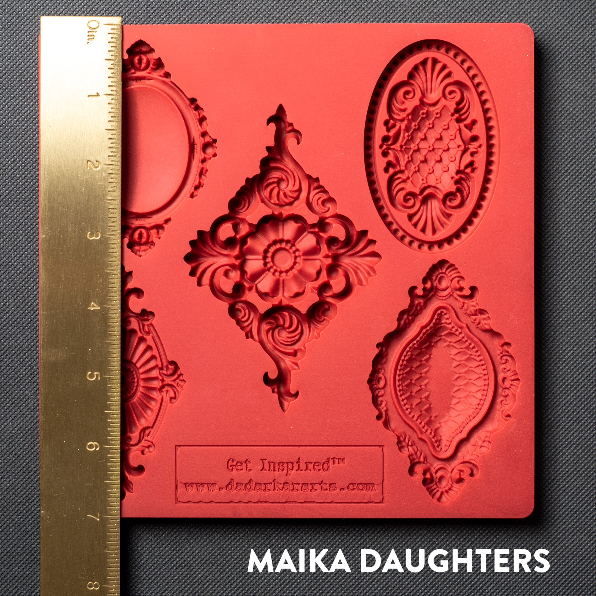 A red silicone mold featuring 5 vintage medallions is against a dark grey background. A gold ruler reading 7 inches in height sits on the mold.