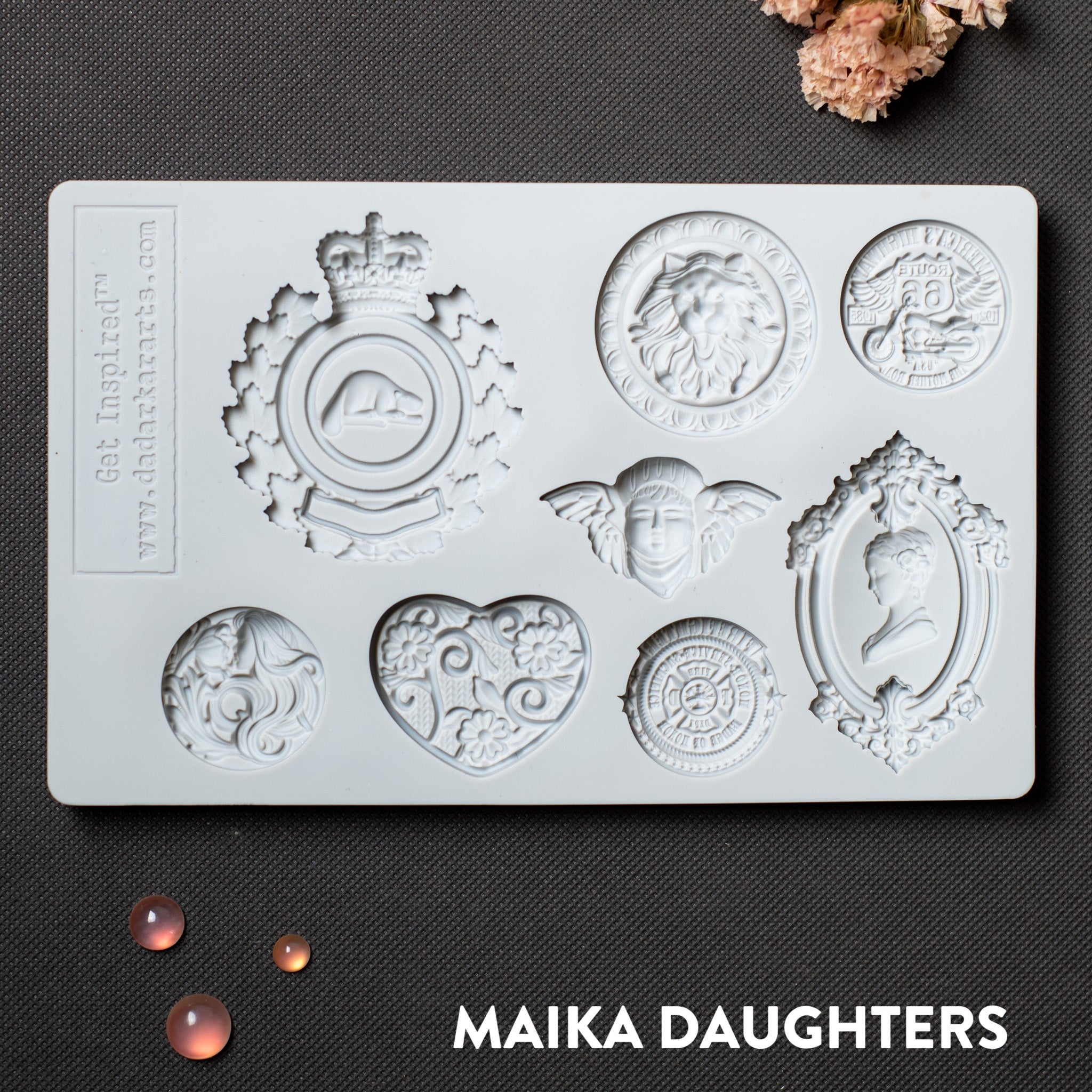 A light grey silicone mold of 8 ornate regal medallions is against a dark grey background.