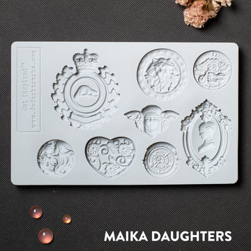 A light grey silicone mold of 8 ornate regal medallions is against a dark grey background.