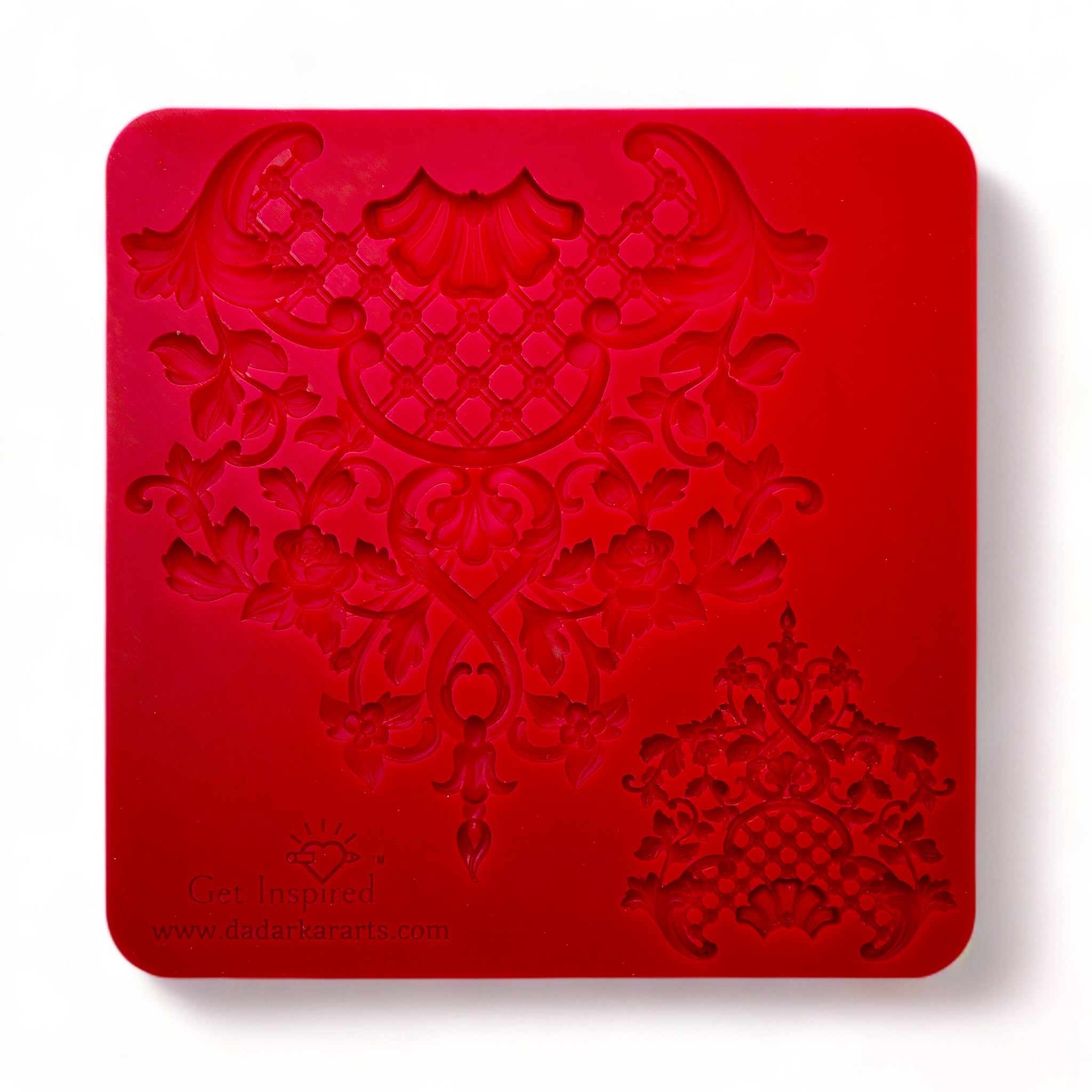 A red silicone mold of 1 large and 1 small vintage floral lattice center piece design is against a white background.