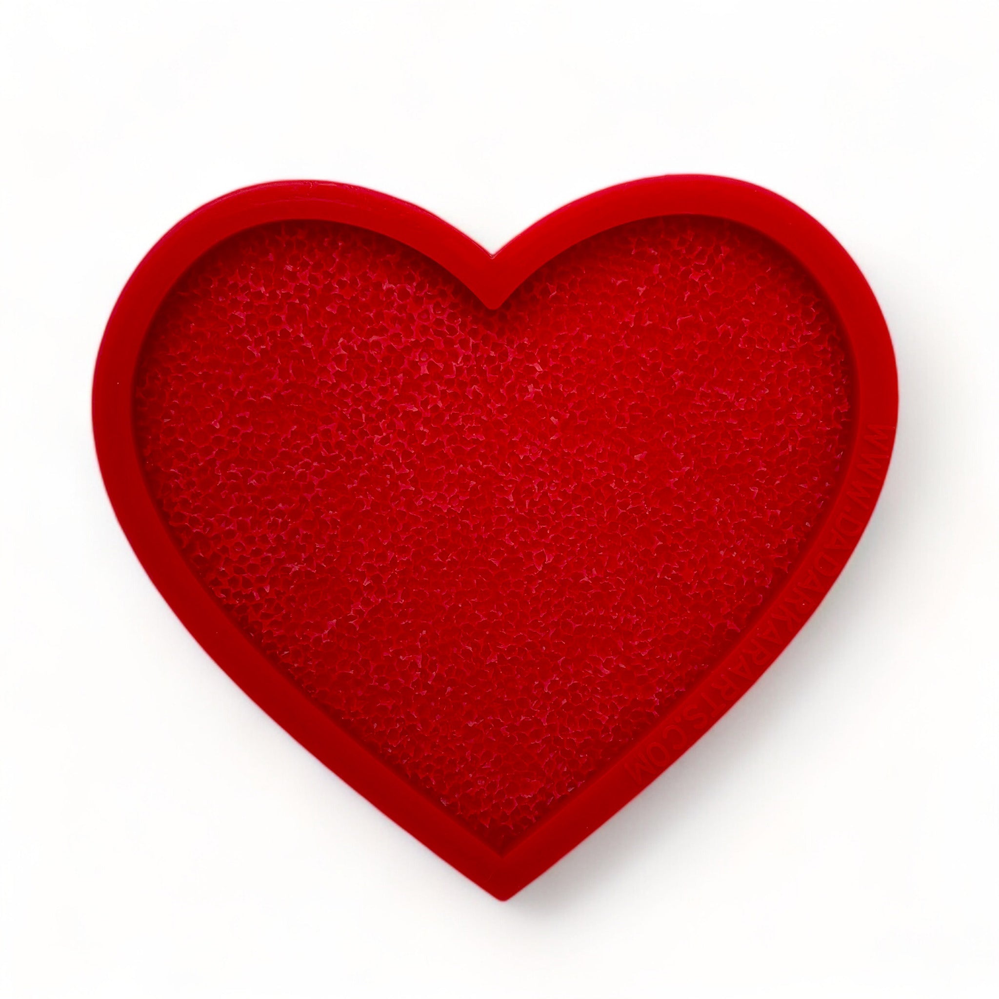 A red silicone mold of a large textured heart is against a white background.