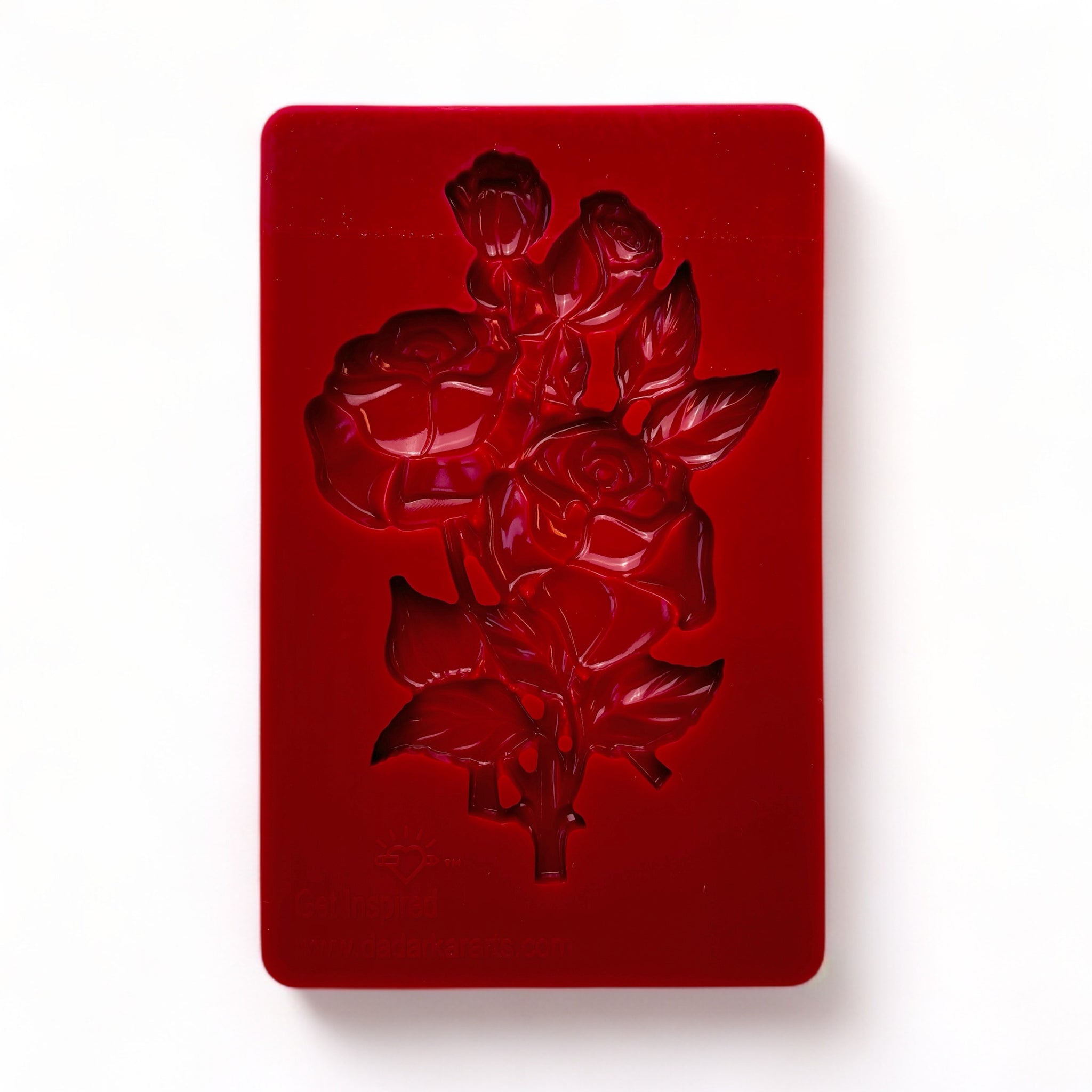 A red silicone mold of a small bouquet of roses is against a white background.