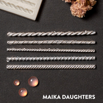 Silver colored castings of 5 mini rope borders are against a dark grey background.