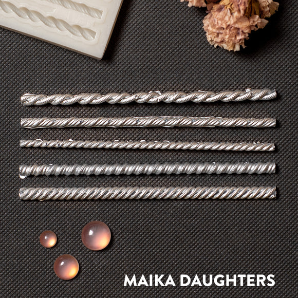 Silver colored castings of 5 mini rope borders are against a dark grey background.