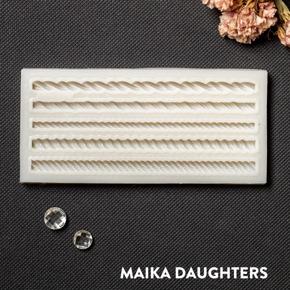 A light beige silicone mold featuring 5 mini rope borders is against a dark grey background.
