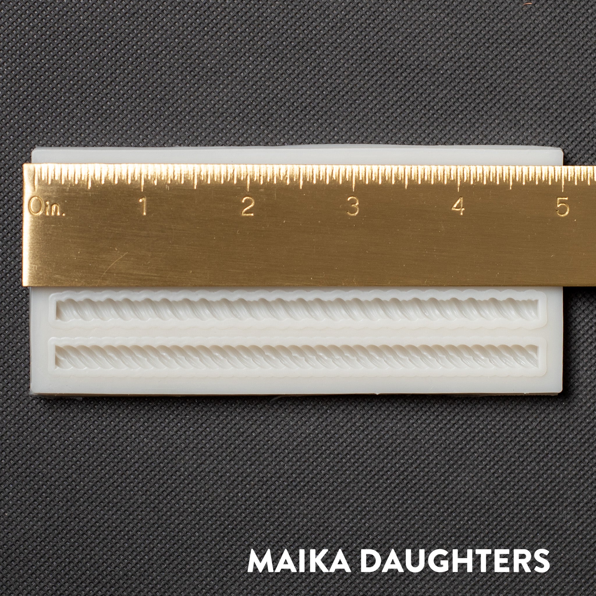 A light beige silicone mold of Get Inspired by Dadarkar Arts Mini Ropes are against a dark grey background. A gold ruler reading 5 inches width sits on the mold.