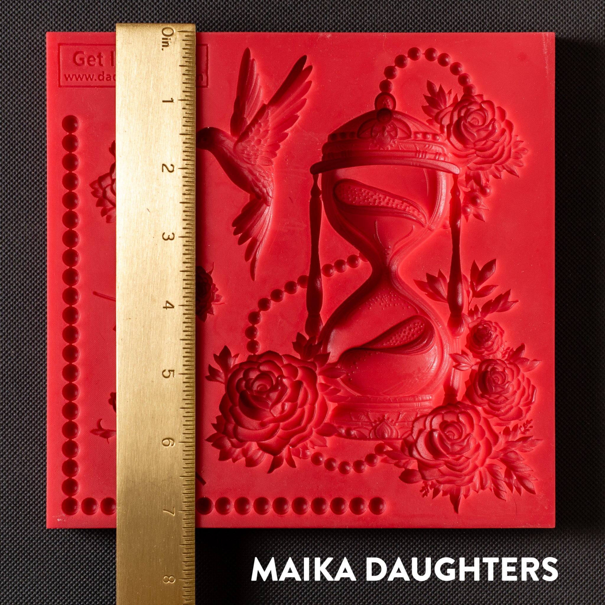 A red silicone mold of Get Inspired by Dadarkar Art's Time Is Flying is against a dark grey background. A gold ruler reading 7.25 inches height sits on the mold.