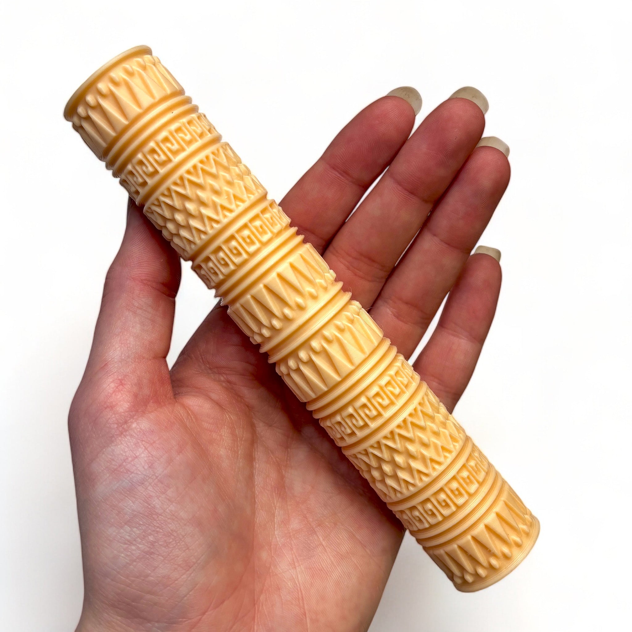 A hand is shown holding Dadakar Art's Aztec Print Texture Roller against a white background.