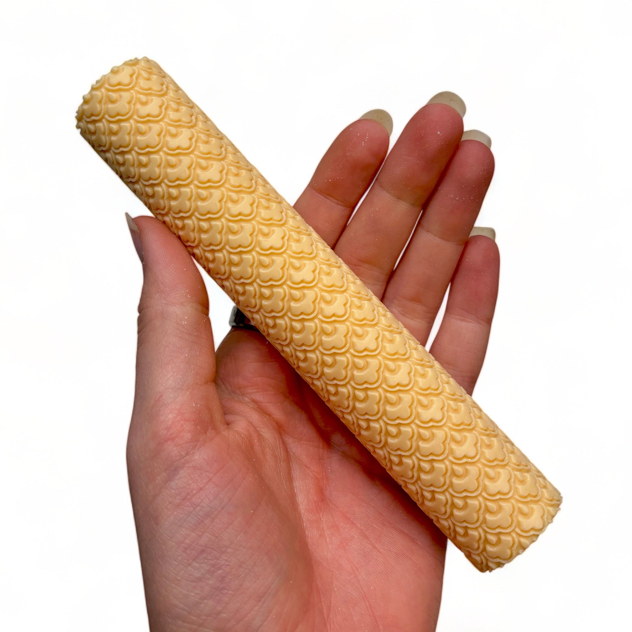 A hand is shown holding Dadakar Art's Curved Flowers Texture Roller against a white background.
