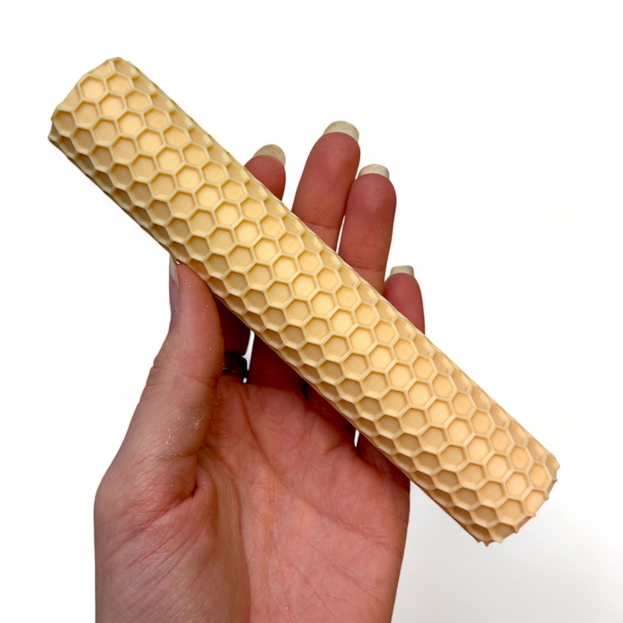 A hand is shown holding Dadakar Art's Honeycomb Texture Roller against a white background.
