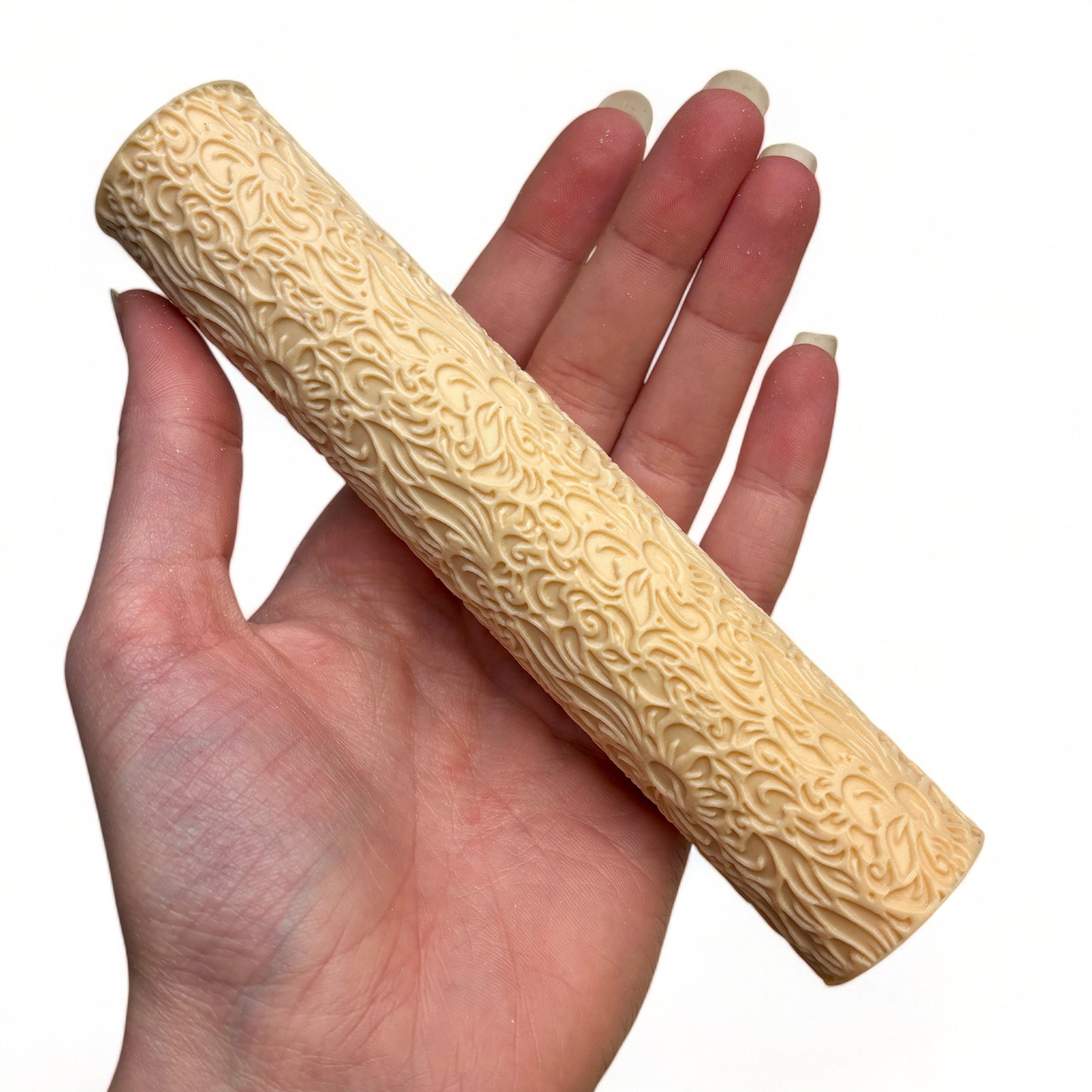 A hand is shown holding Dadakar Art's Organic Flowers Texture Roller against a white background.
