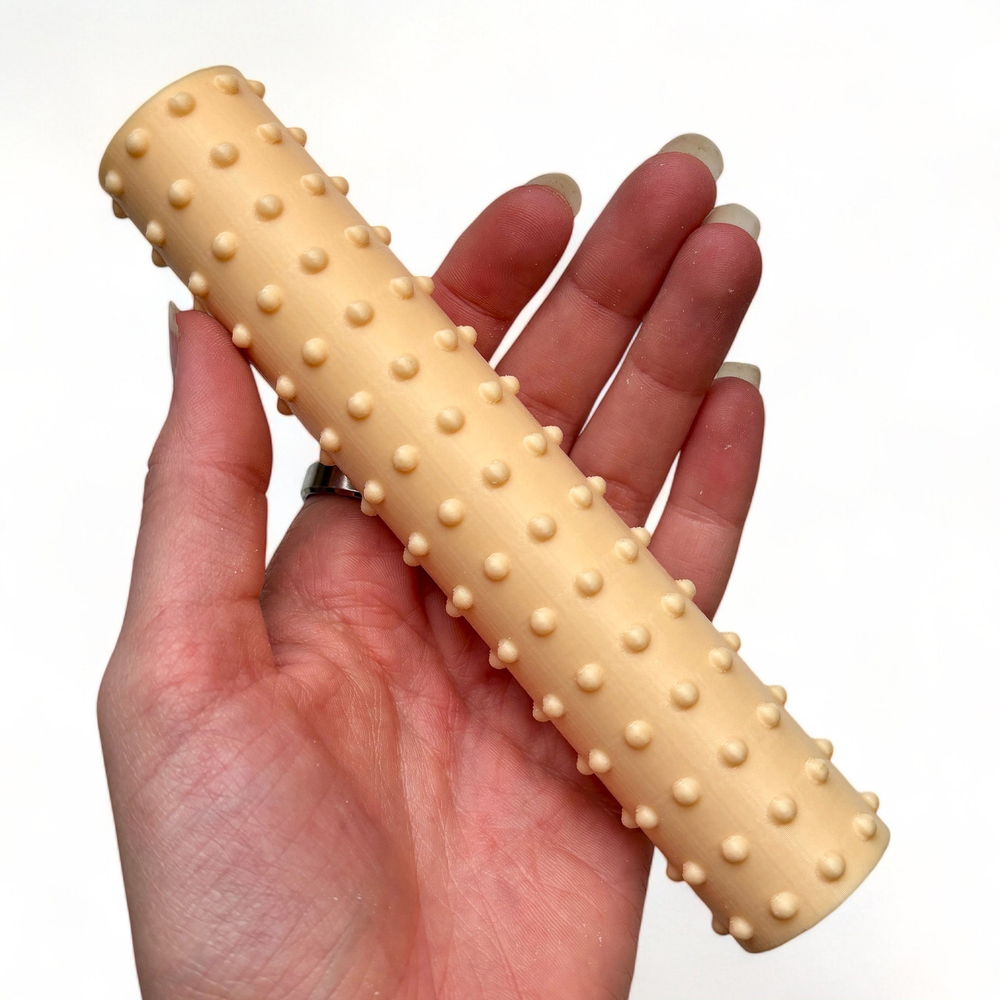 A hand is shown holding Dadakar Art's Polka Dots Texture Roller against a white background.
