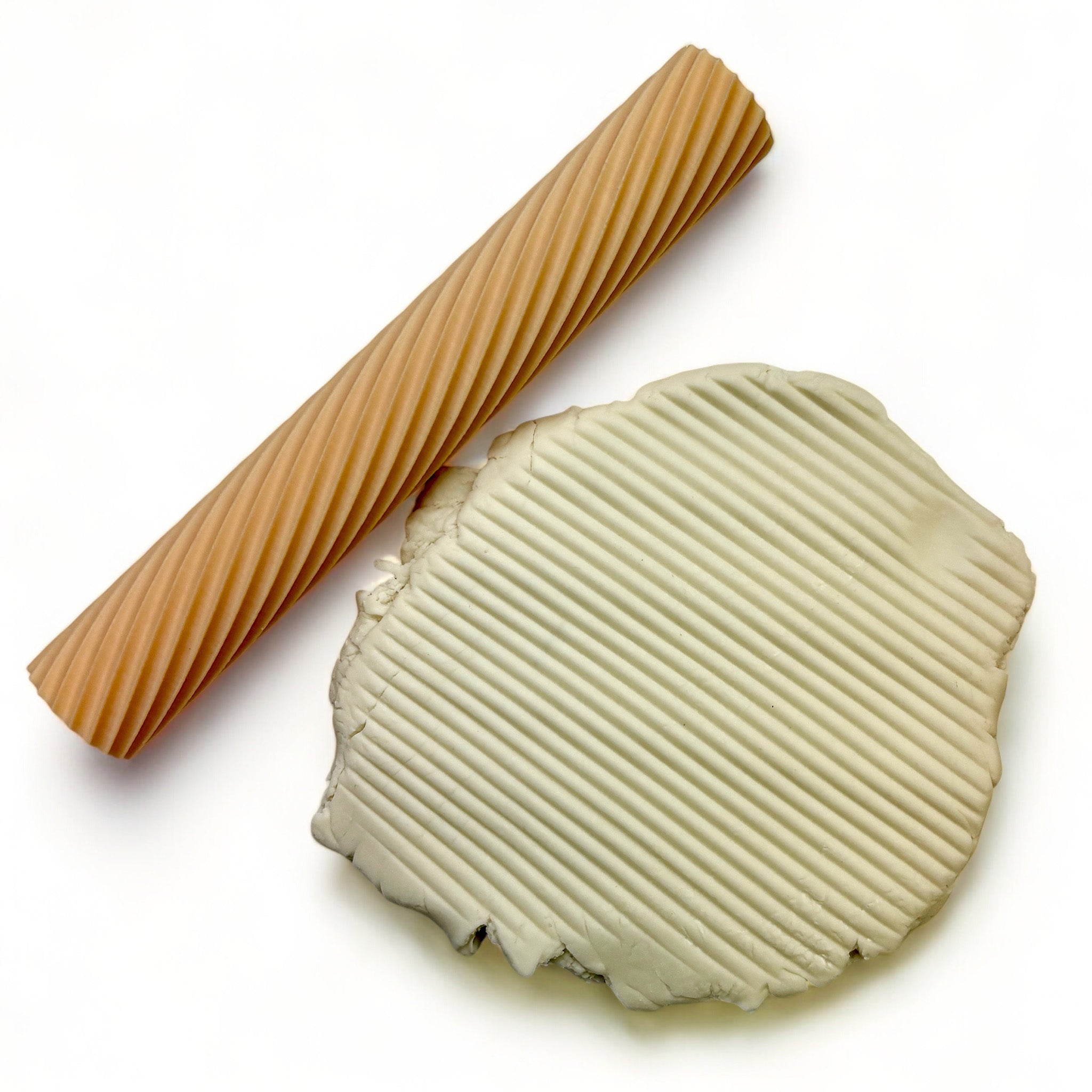 A seamless texture roller and flattened chunk of clay featuring a small stripe pattern are against a white background.
