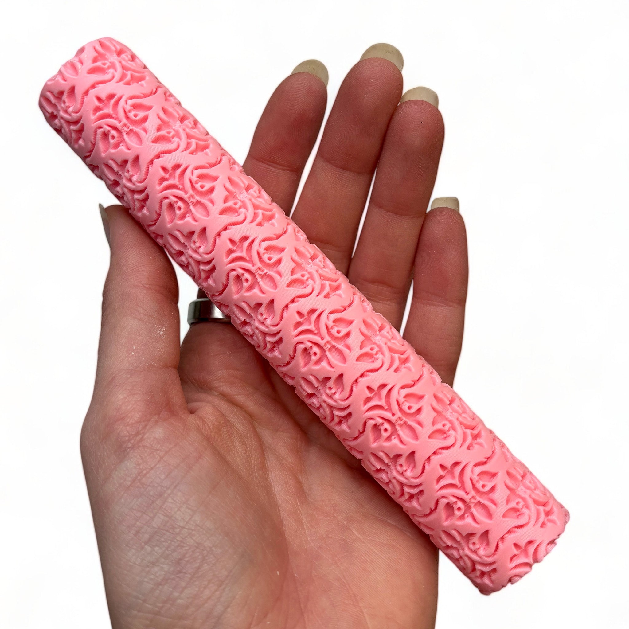 A hand is shown holding Dadakar Art's Tanglewood Damask Texture Roller against a white background.
