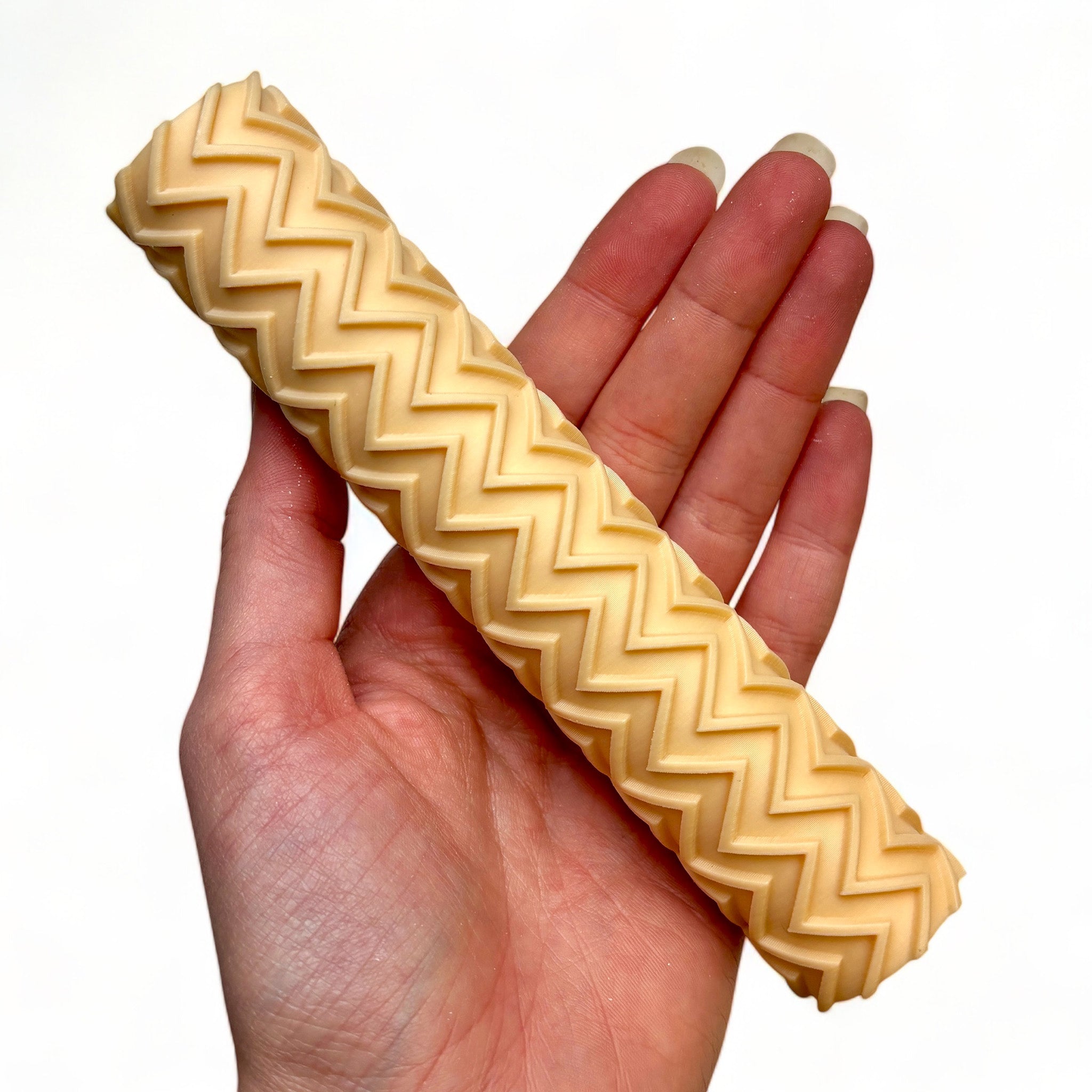 A hand is shown holding Dadakar Art's Zig Zag Pattern Texture Roller against a white background.
