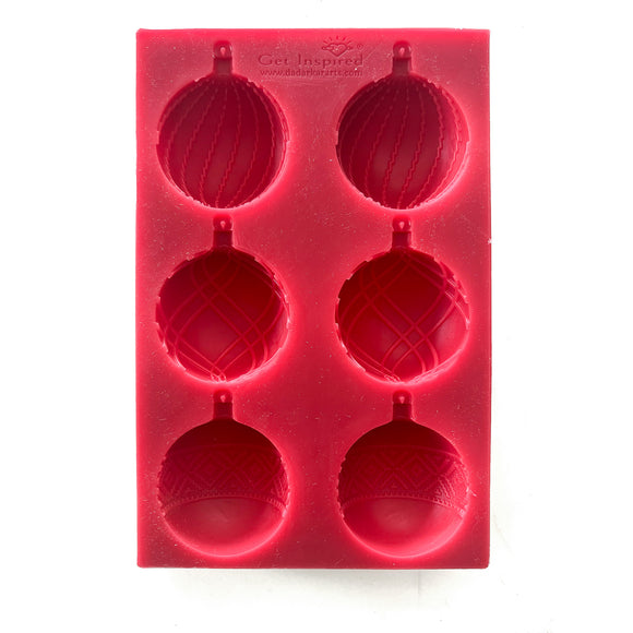 A red silicone mold that features 6 ornate half ornaments that make 3 full ornaments is against a white background.