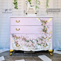A vintage 4-drawer dresser refurbished by Shabby Chic & Co. is painted pale lavender with gold accents and features ReDesign with Prima's Blossom Botnica on its bottom 2 drawers going up the right front-side of the top 2 drawers.