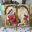 An open book turned into a decor piece features Decoupage Queen's Papillon Poppies rice paper on it.