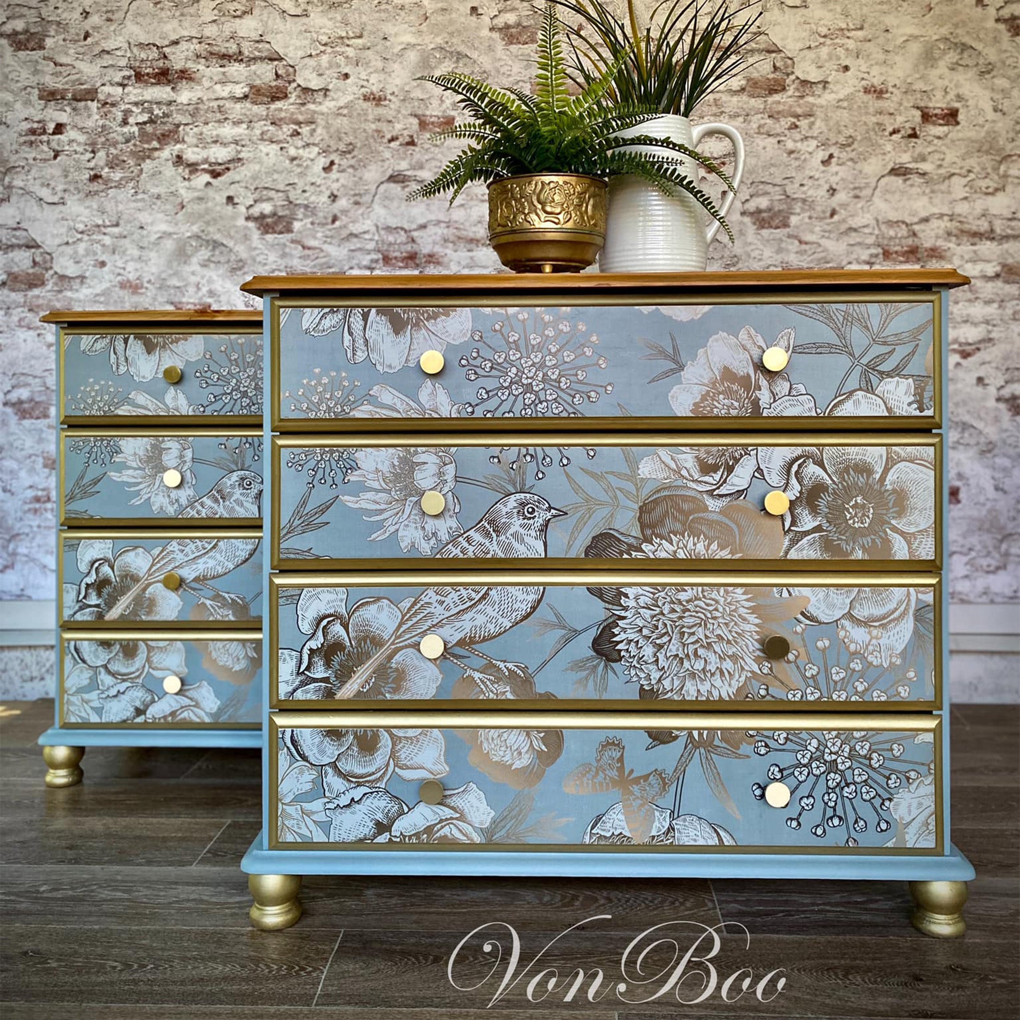 Two 4-drawer dressers refurbished by Von Boo are painted light blue with gold accents and feature Mint by Michelle's Foil Birds decoupage paper on the drawers.