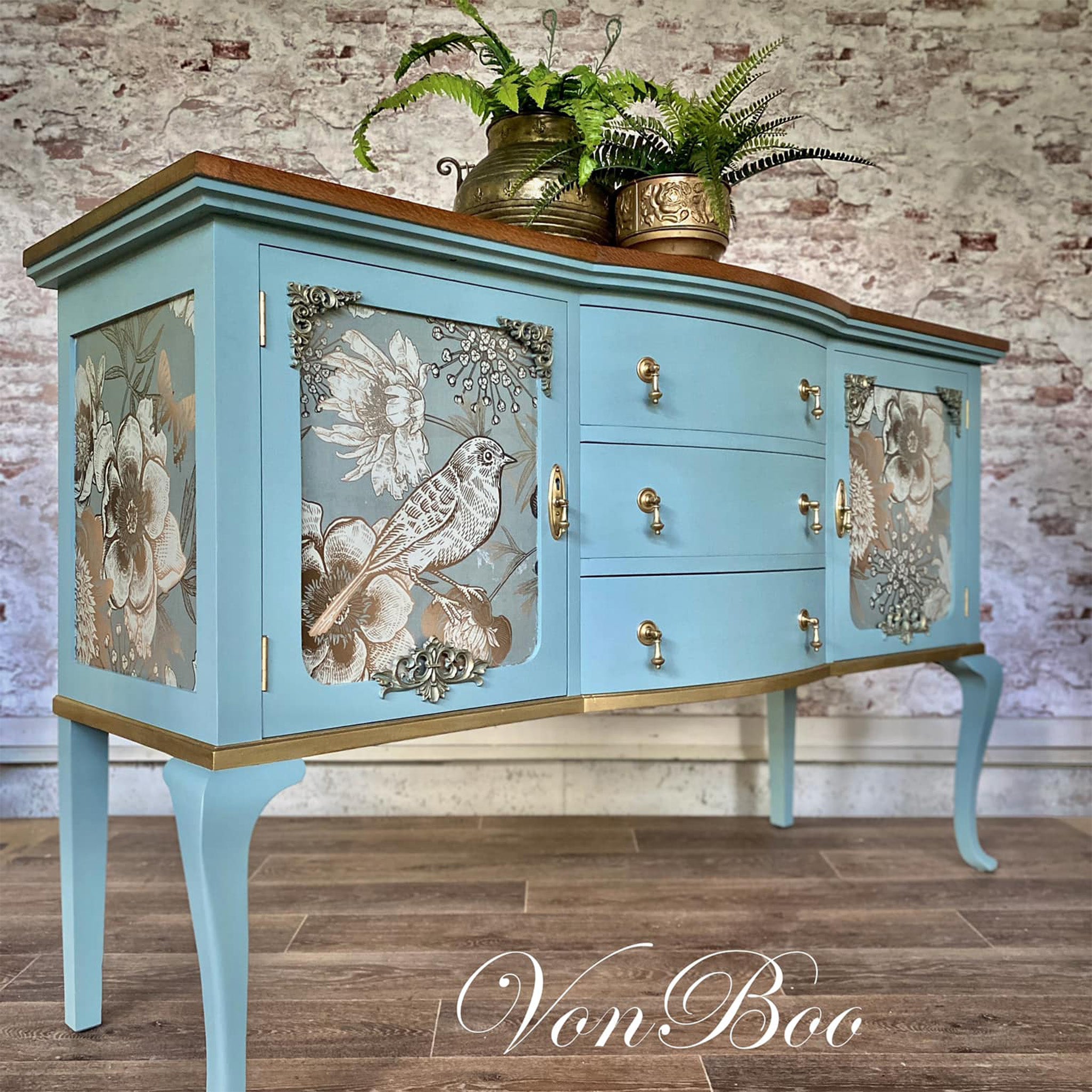 A vintage console table with storage refurbished by Von Boo is painted light blue with gold accents and features Mint by Michelle's Foil Birds decoupage paper on its 2 door inlays and side panels.