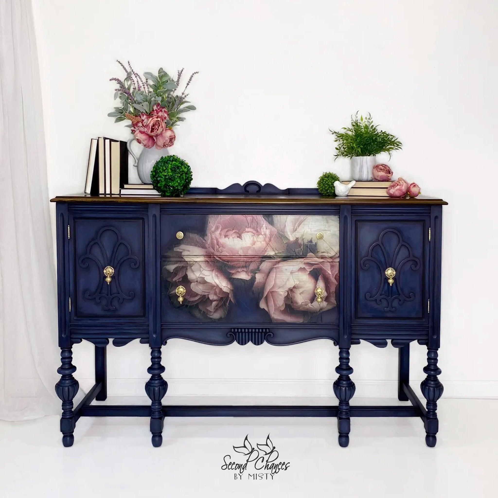 A vintage console table refurbished by Second Chances by Misty is painted navy blue and features Mint by Michelle's Moody Florals 1 decoupage paper on its 2 center drawers.