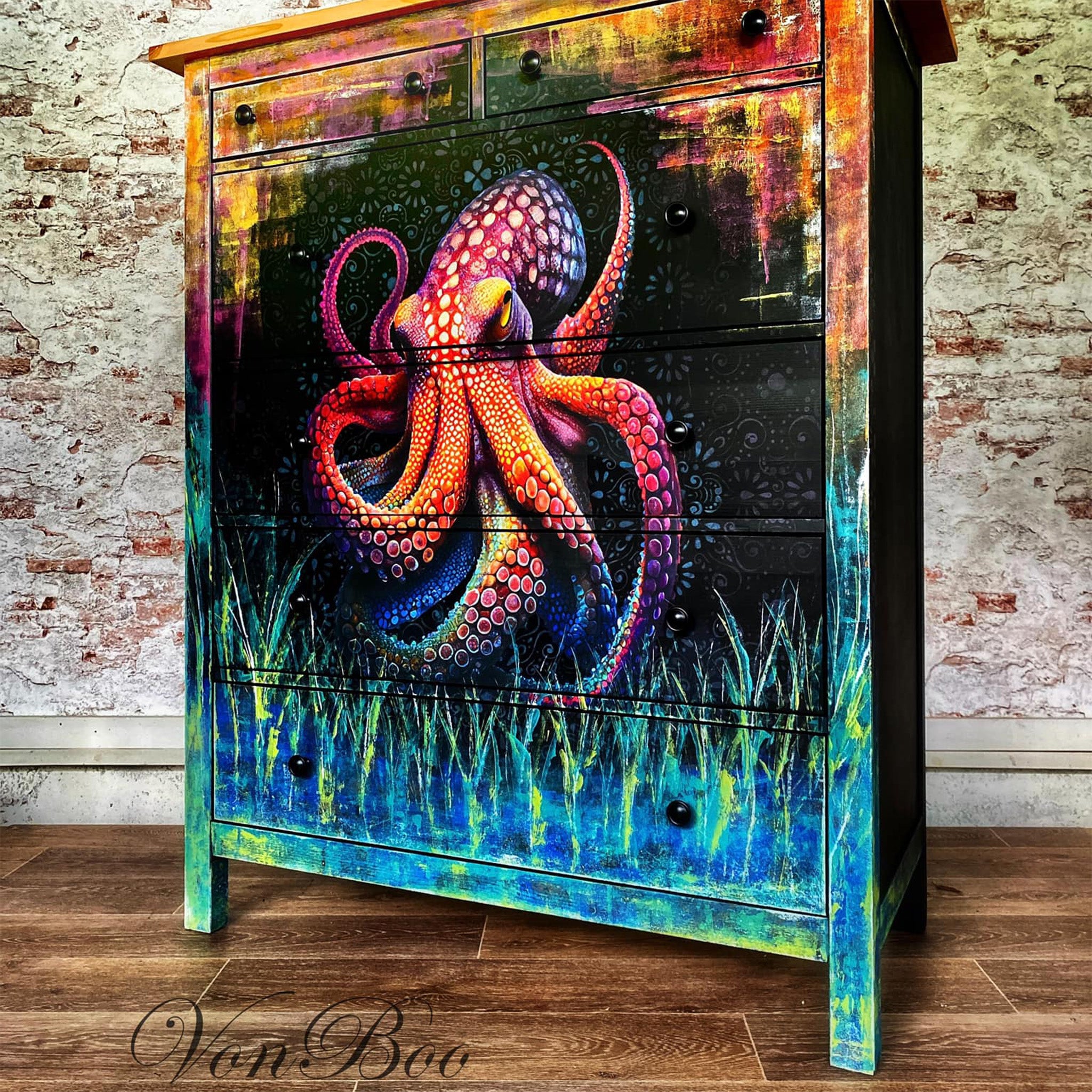 A 6-drawer chest dresser refurbished by Von Boo is painted a blend of blues and greens, and oranges and pinks, and features Mint by Michelle's Octopus Black decoupage paper on the front center.