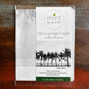 A package of Mint by Michelle's Palm Trees A3 decoupage paper is against a dark wood background.