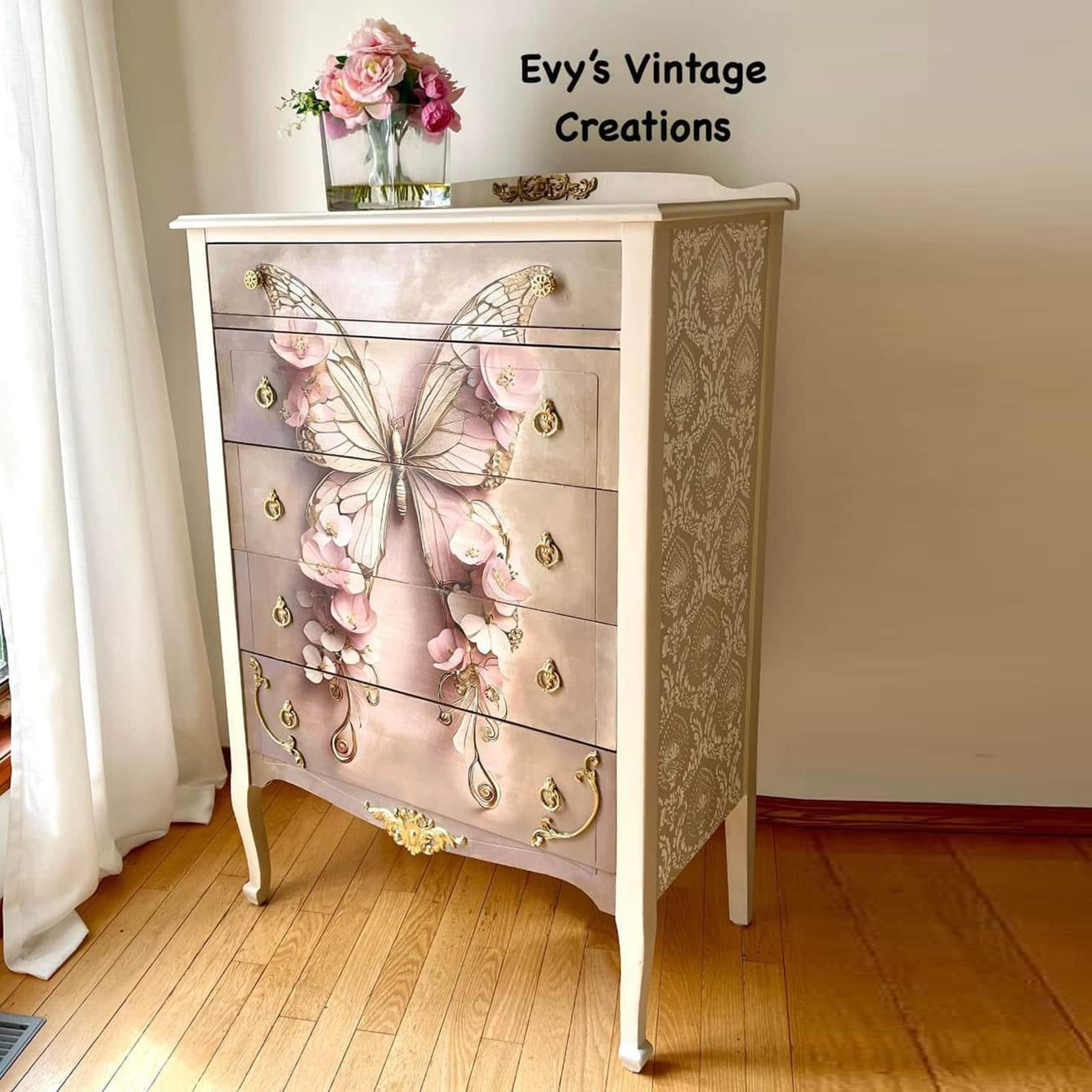 A vintage 5-drawer dresser refurbished by Evy's Vintage Creations is painted light beige and features Mint by Michelle's Pink Butterfly decoupage paper on the front.