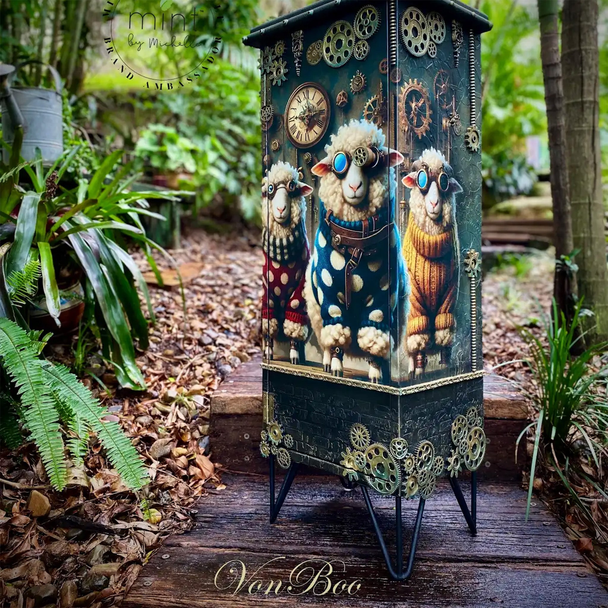 A vintage standing jewelry armoire is painted blue with gold colored steampunk cogs and gears and features Mint by Michelle's Shaun Sheep on it.