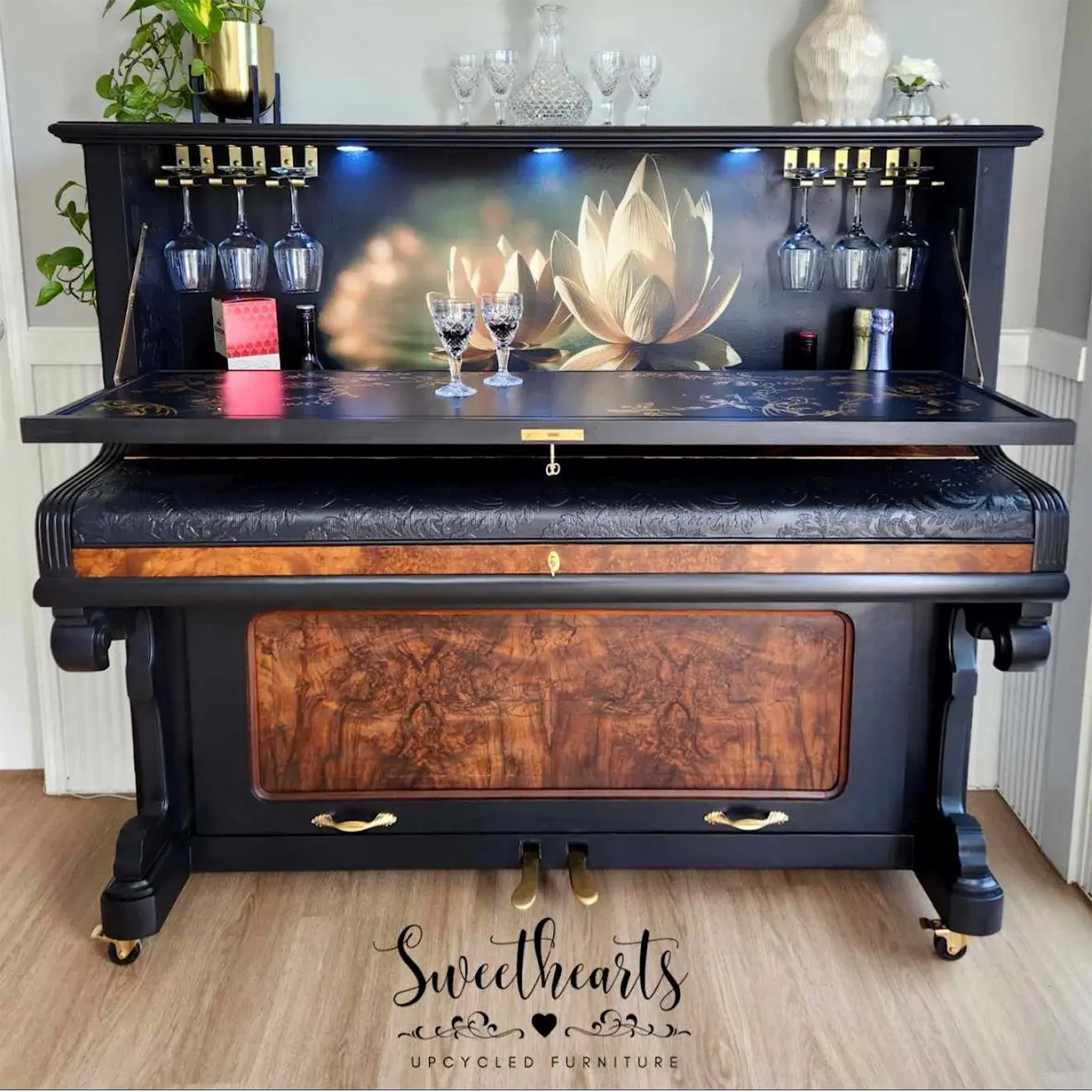 A vintage piano transformed into a bar by Sweethearts Upcycled Furniture is painted black with burlwood and features Mint by Michelle's Water Lily decoupage paper as the inner backdrop.