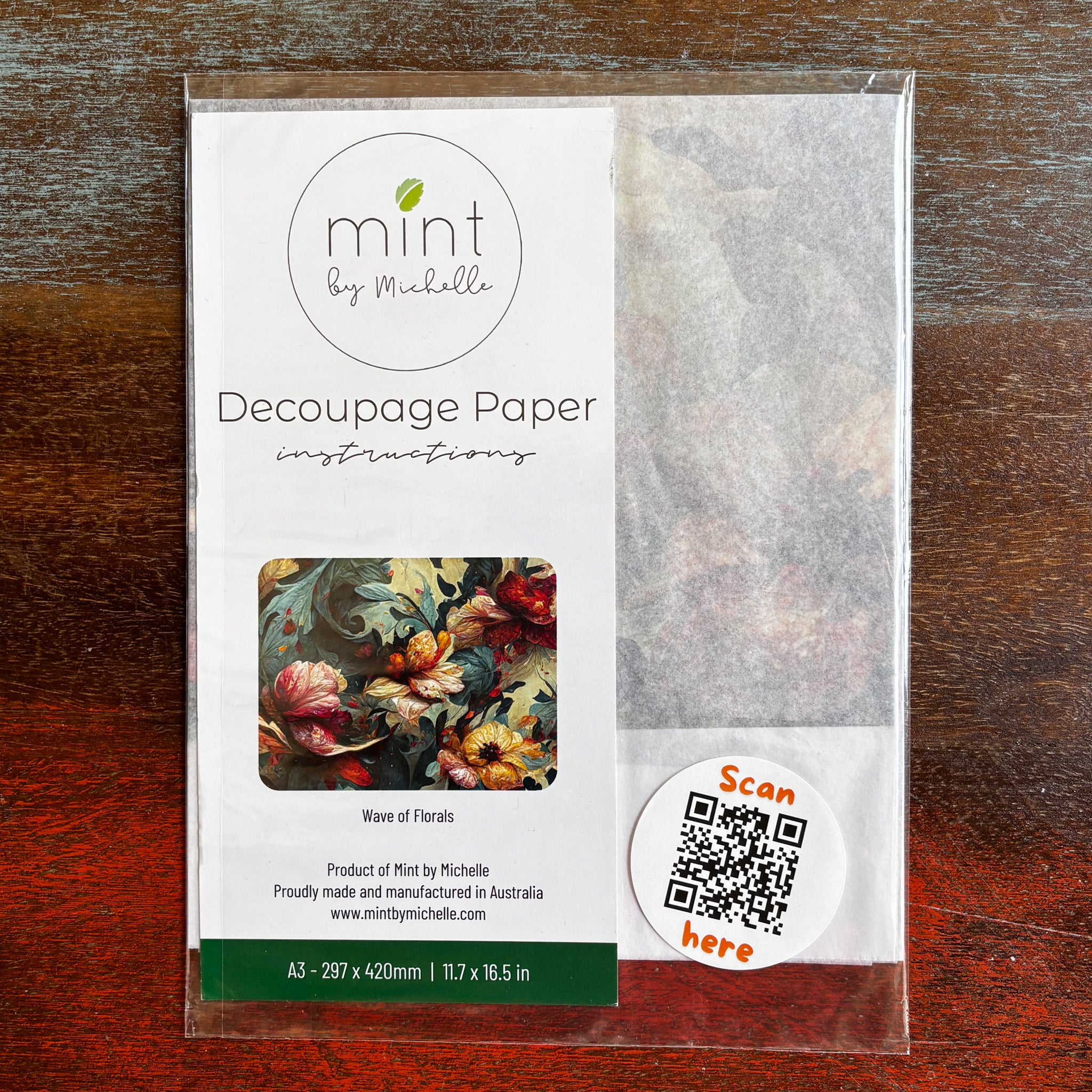 A package of Mint by Michelle's Wave of Florals A3 decoupage paper is against a dark wood background.