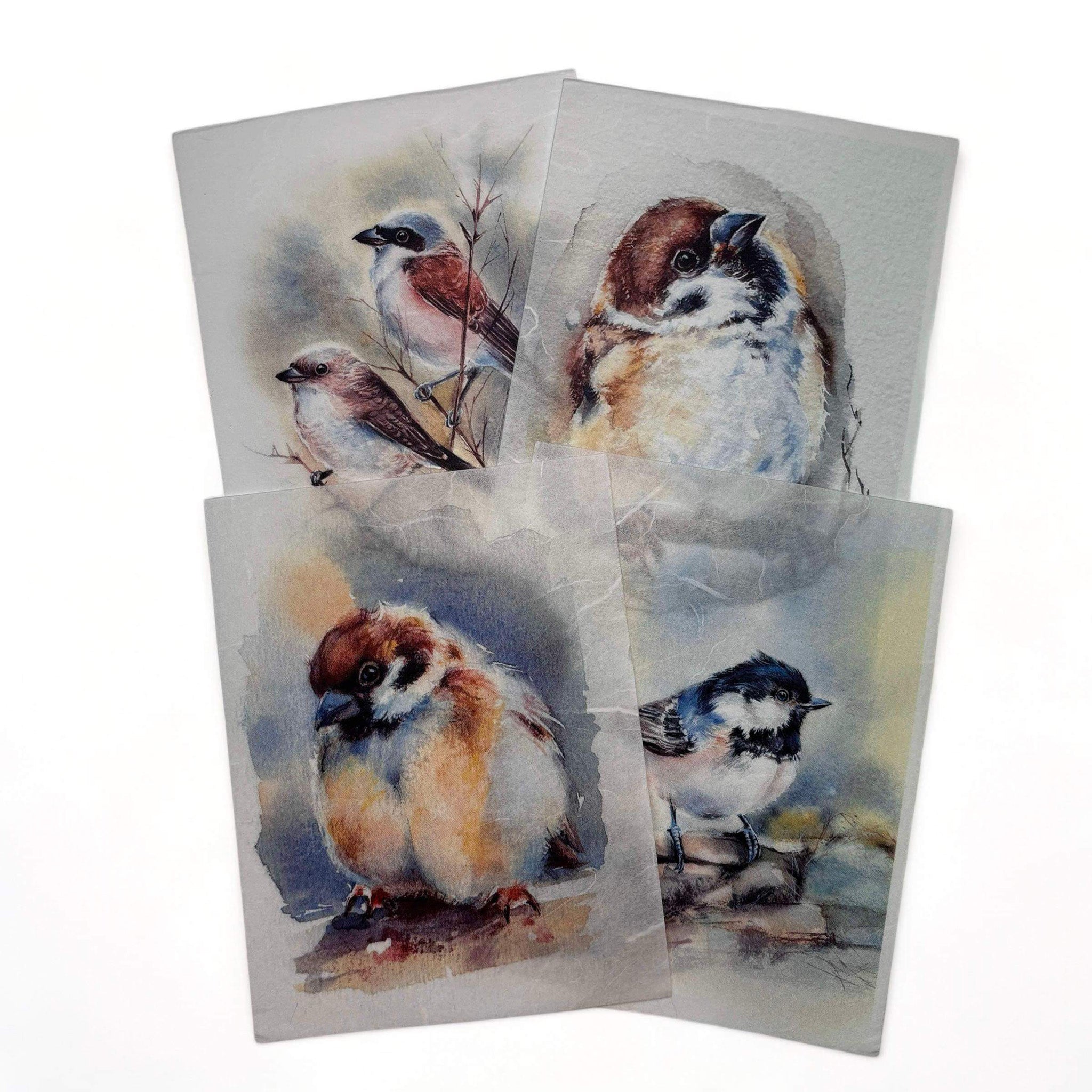 Four rice papers that feature adorable small bird designs in vibrant watercolors are against a white background.