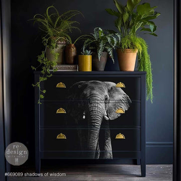 A dresser is painted dark navy blue and features ReDesign with Prima's Shadows of Wisdom A1 fiber paper on its 3 drawers.