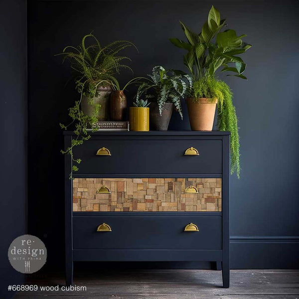 A 3-drawer dresser is painted midnight blue and features ReDesign with Prima's Wood Cubism A1 fiber paper on its middle drawer.