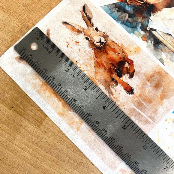 A close-up of Decoupage Queen's Four Abundance Scenes A4 rice paper shows a silver ruler over one of the designs showing a measurement of 5.75 inches high.