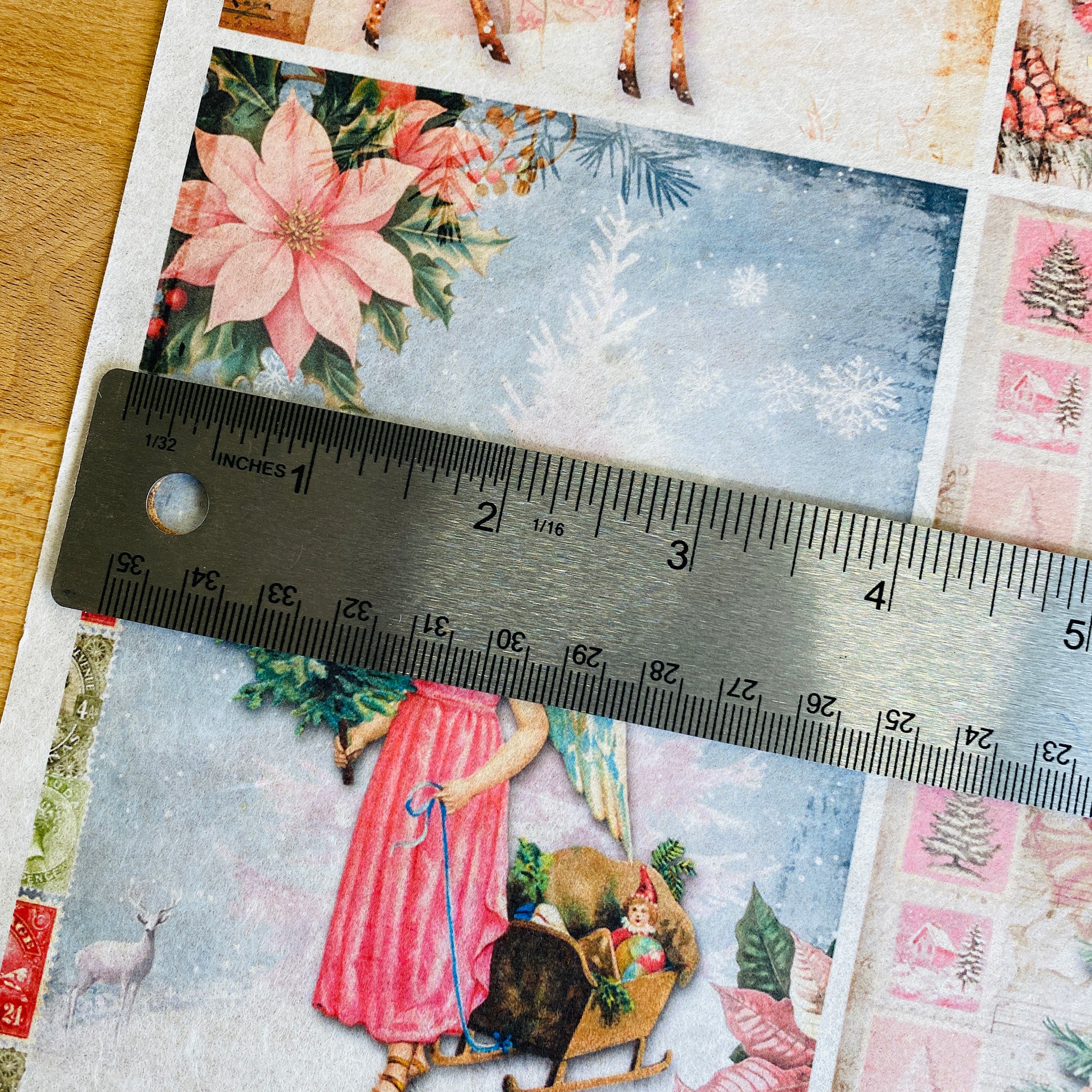 A close-up of Decoupage Queen's Four Pink Winter Scenes A4 rice paper shows a silver ruler over one of the designs showing a measurement of 4 inches across.