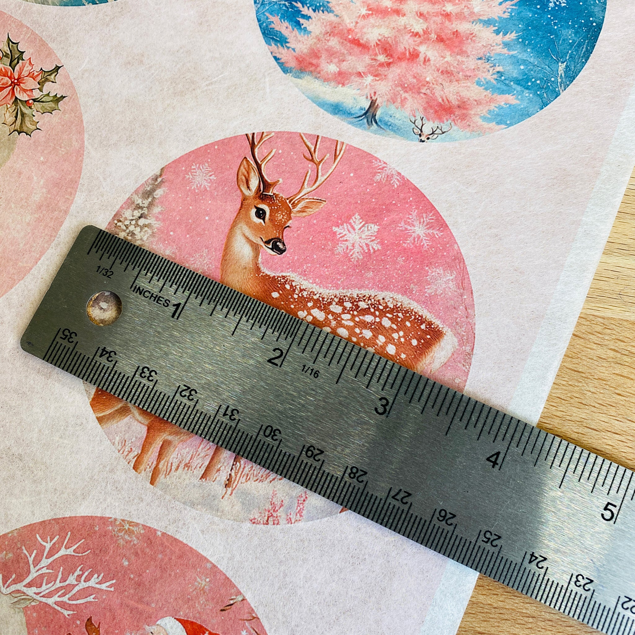 A close-up of Decoupage Queen's Pink Winter Ornaments A4 rice paper shows a silver ruler over one of the designs measuring 3.5 inches diameter.