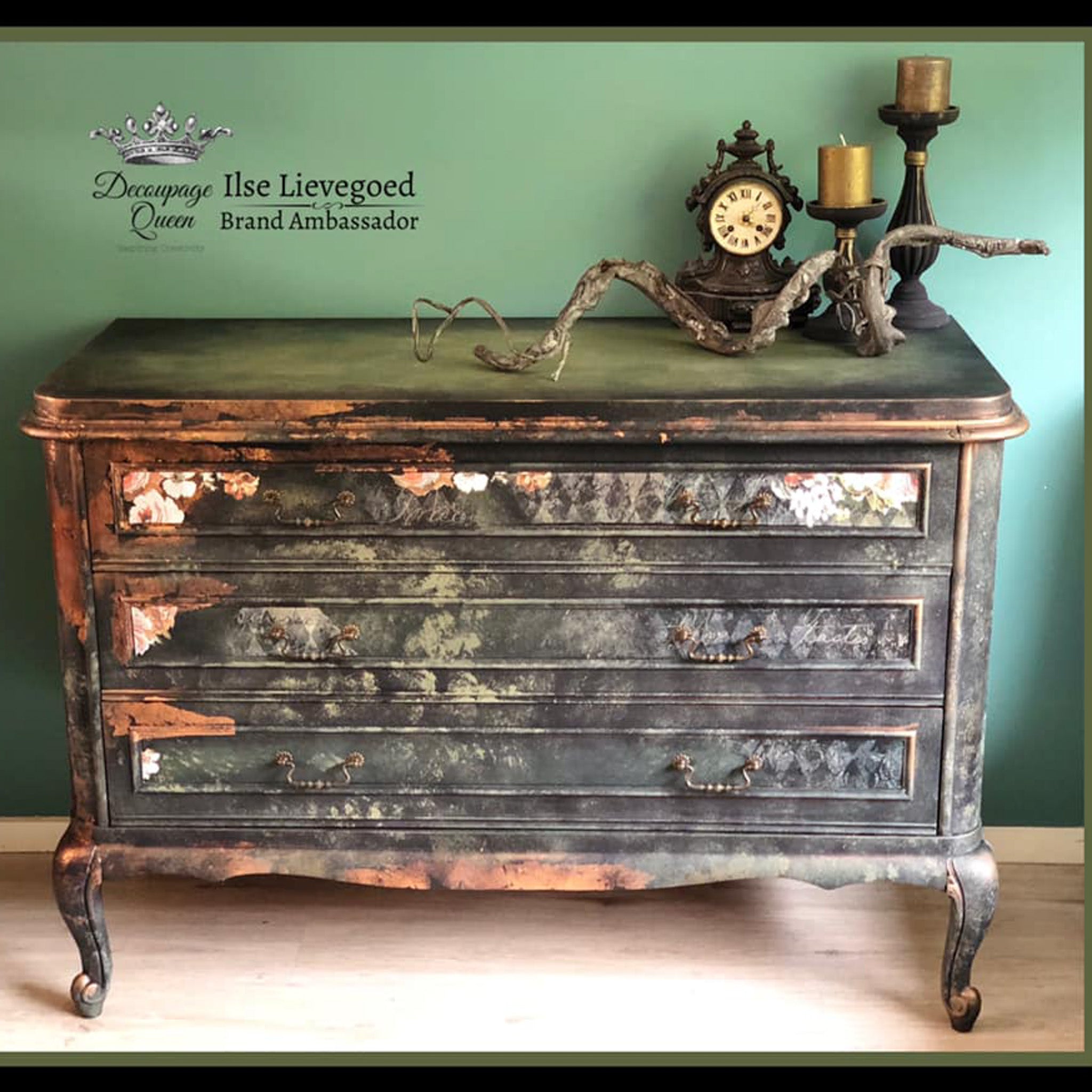 A vintage large 3-drawer dresser refurbished by Ilse Lievegoed is painted black with copper accent and features Decoupage Queen's Black and Gold Harlequin rice paper on its drawers.