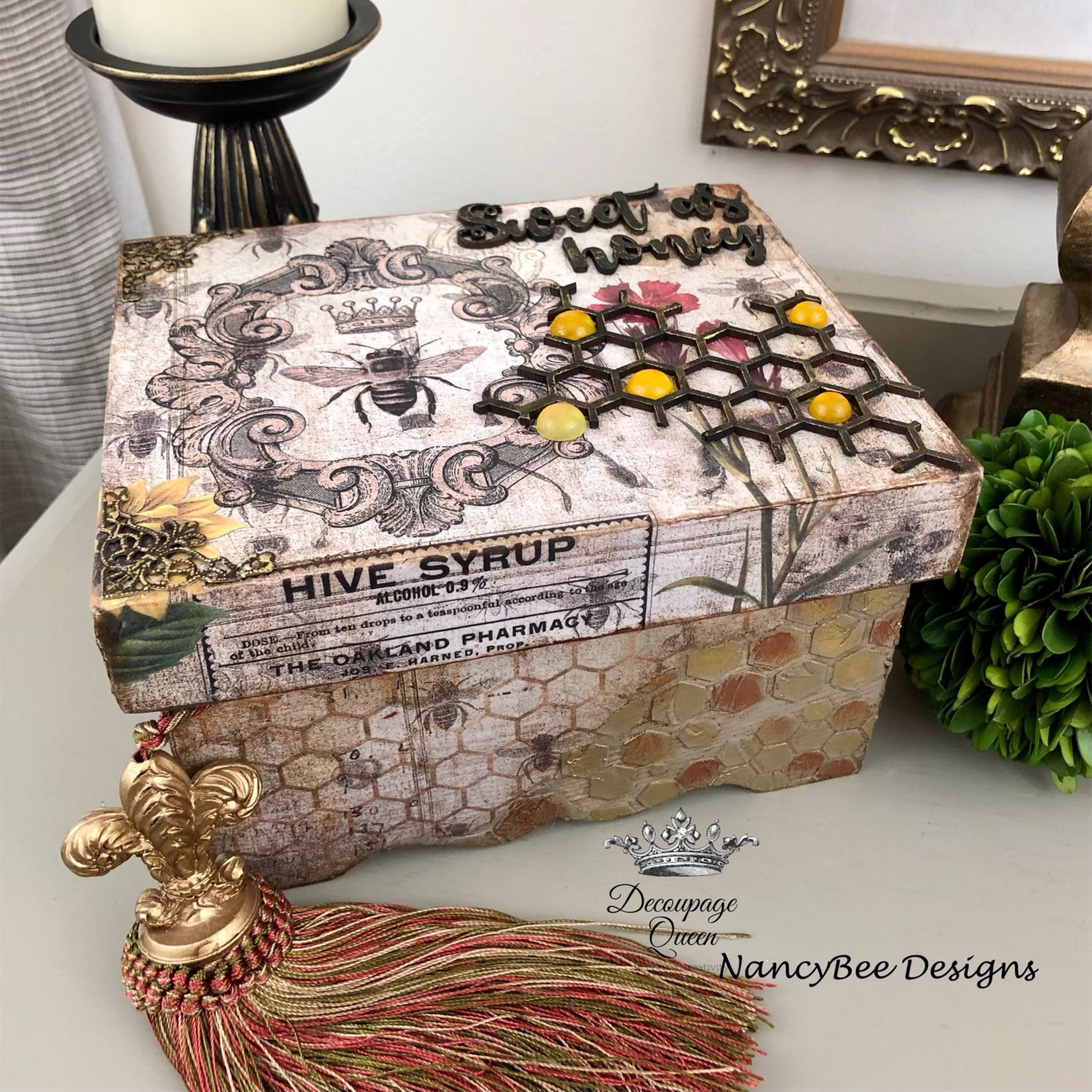 A paper craft box created by Nancy Bee Designs features Decoupage Queen's Hive Syrup rice paper on it.