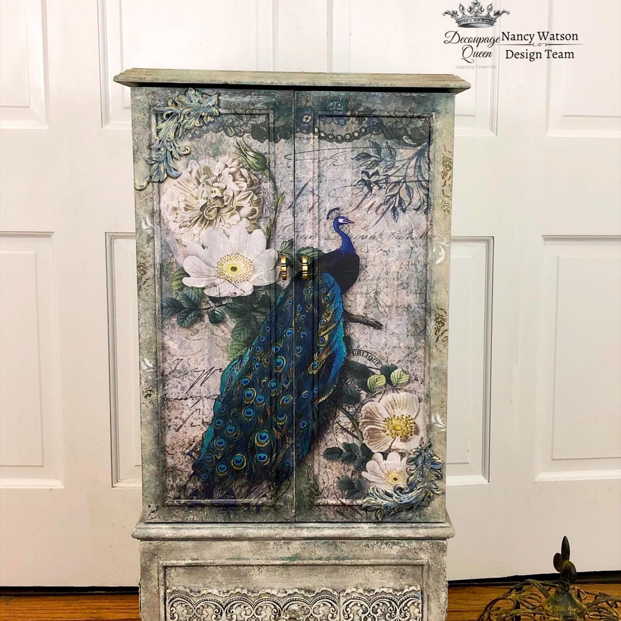 Rustic dresser with the Peacock Majesty decoupage paper on top. A Decoupage Queen and Nancy Watson Design Team logo on the top right.