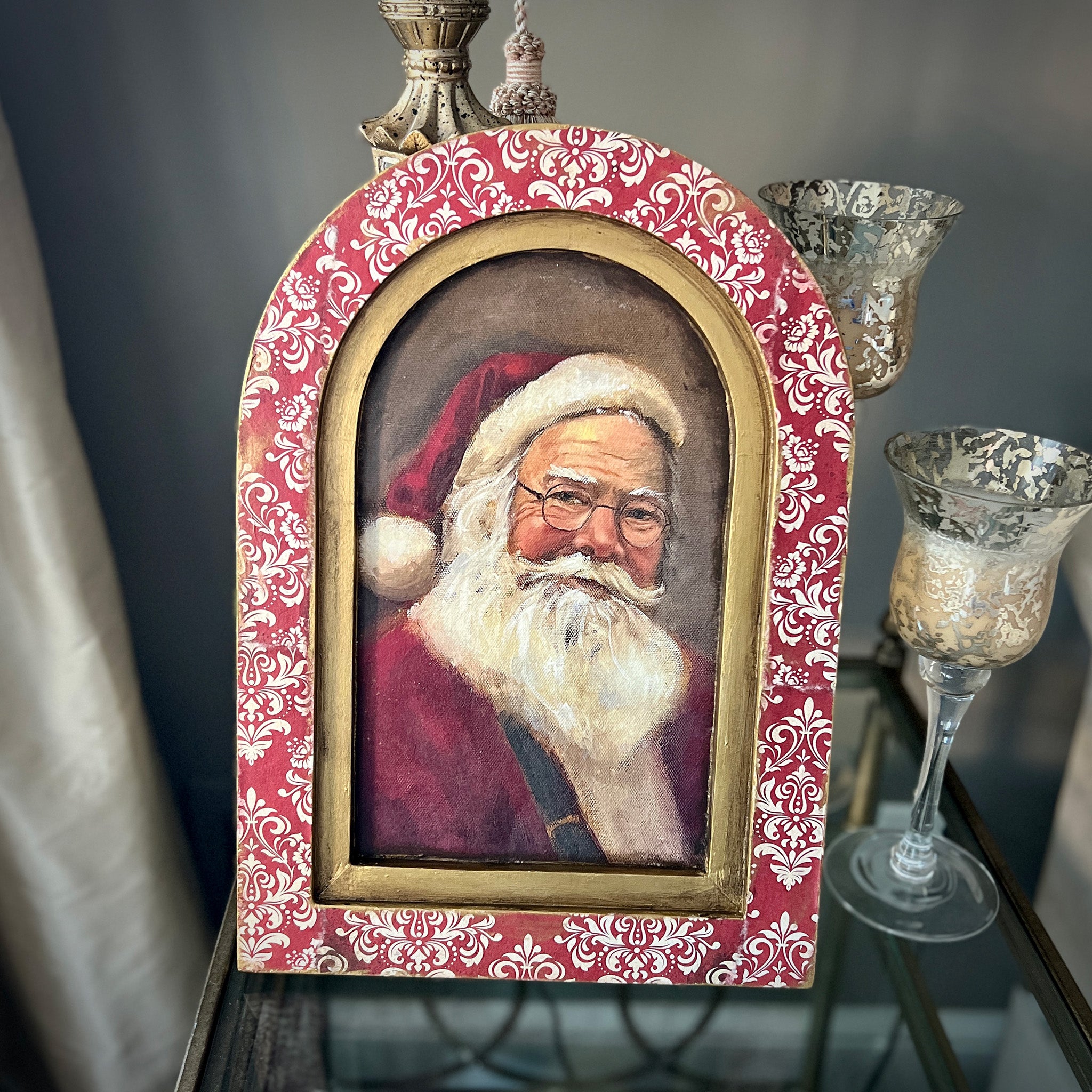 A wood arch frame with a portrait of Santa features Decoupage Queen's Red Christmas Damask rice paper on the frame.