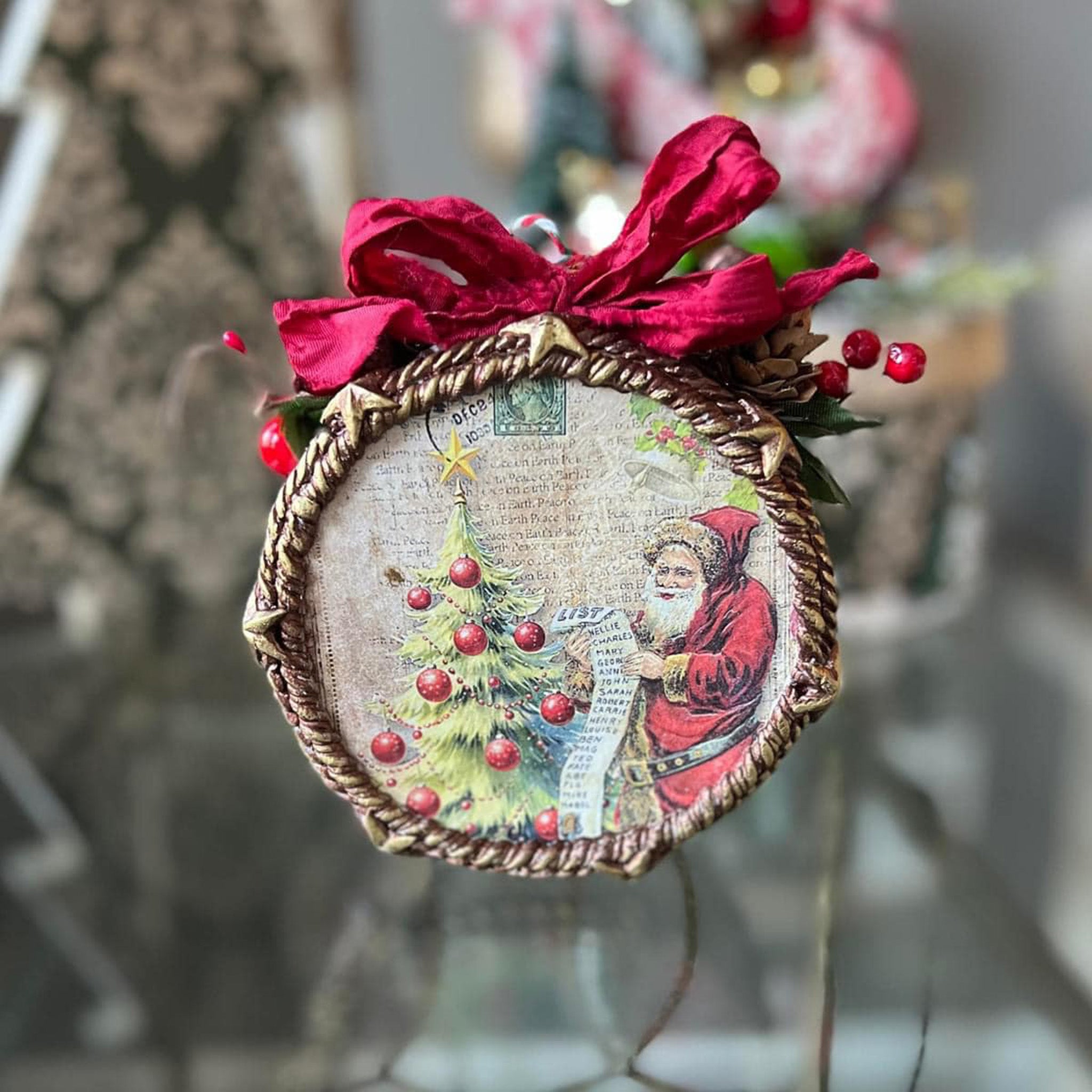 A Christmas bauble ornament with a flat face features Decoupage Queen's Santa's List rice paper on it.