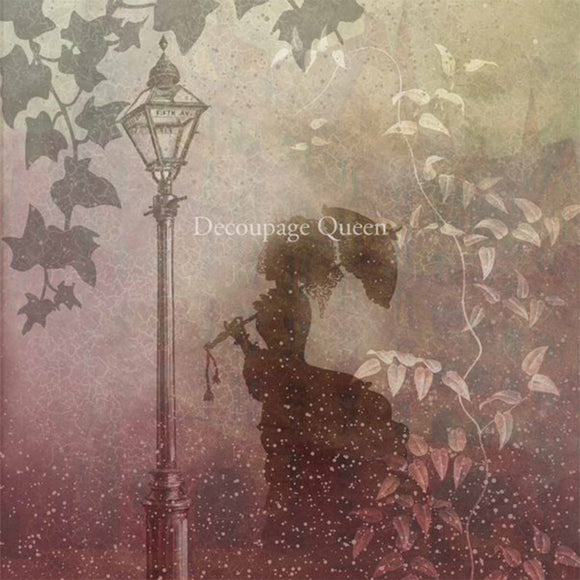 Close-up of a rice paper featuring the silhouette of a woman with an umbrella by a street lamp surrounded by leaves.