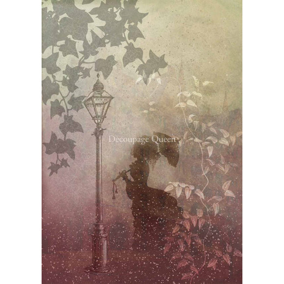 Rice paper featuring the silhouette of a woman with an umbrella by a street lamp surrounded by leaves. White borders are on the sides.